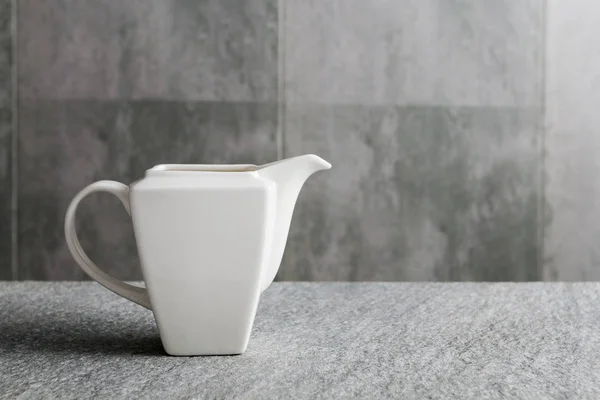 Porcelain sauce boat on gray background