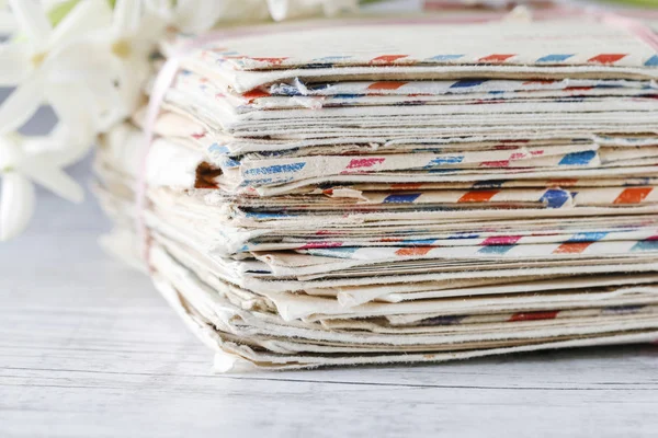 Stapel alter Buchstaben und weißer Hyazinthenblüten. — Stockfoto