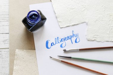 Kaligrafi, beyaz kağıda el yazısı harfler.