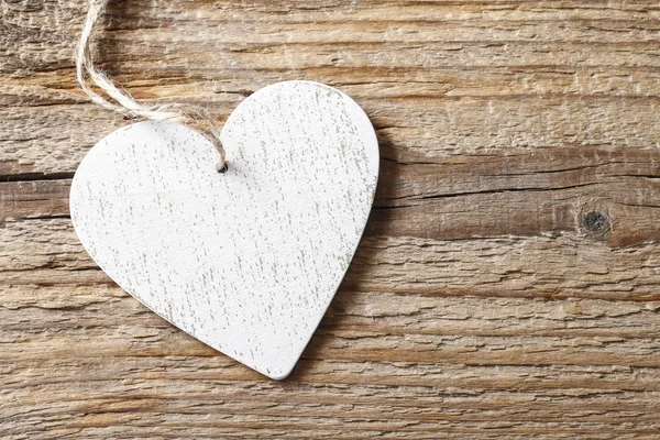 Белое сердце на деревянном фоне — стоковое фото