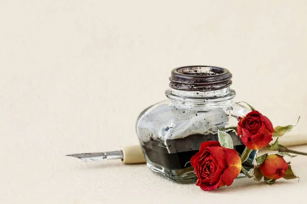 Vintage kağıt arka plan üzerinde Mürekkep kuyusu, kalem ve kurutulmuş güller — Stok fotoğraf
