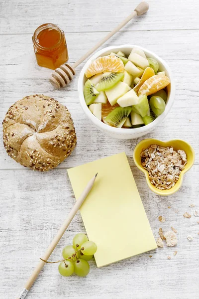 Yellow notebook and healthy food on wooden table — Stock Photo, Image