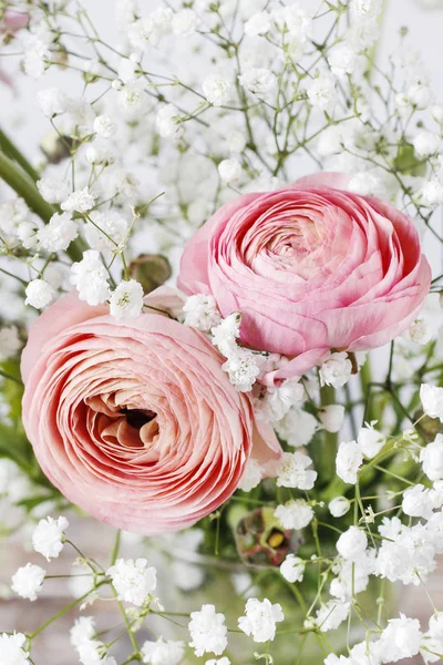 Rosafarbene Hahnenfußblüten und winzige weiße Zigeunerblume. — Stockfoto