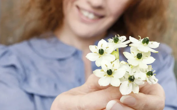Mulher segurando buquê de pequenas flores brancas — Fotografia de Stock