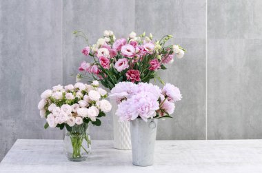 Güller, şakayıklar ve lisianthus (eustoma) gri duvar arka plan üzerinde