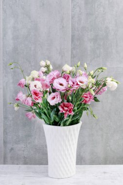 Gri taş arka plan üzerinde pembe eustoma (lisianthus) çiçekleri.