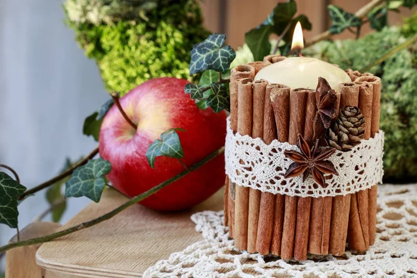 Candle decorated with cinnamon sticks — Stock Photo, Image