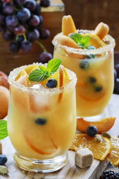 Summer drink with peaches, oranges and blueberries.