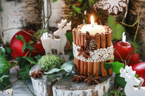 Candle decorated with cinnamon sticks, moss, ivy leaves and wood — Stock Photo, Image