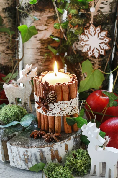 Свечи украшены корицей палочки, мох, листья плюща и дерева — стоковое фото