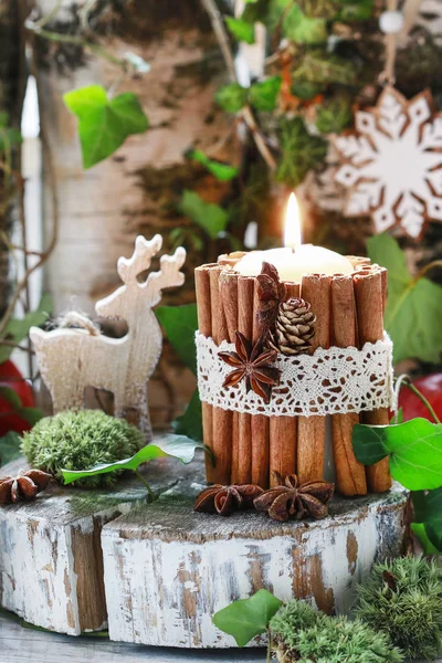 Candle decorated with cinnamon sticks, moss, ivy leaves and wood — Stock Photo, Image