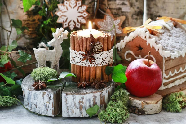 Candle decorated with cinnamon sticks, moss, ivy leaves and wood — Stock Photo, Image