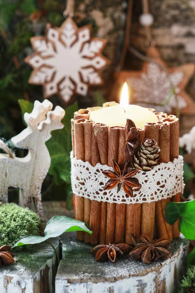 Candle decorated with cinnamon sticks, moss, ivy leaves and wood — Stock Photo, Image