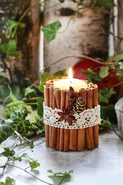 Candle decorated with cinnamon sticks, moss, ivy leaves and wood — Stock Photo, Image