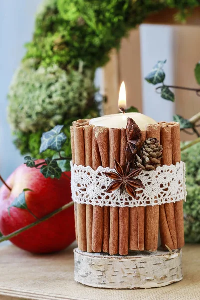 Candle decorated with cinnamon sticks — Stock Photo, Image