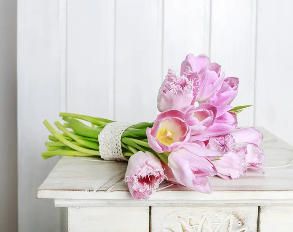 Buquê de tulipas rosa deitado sobre a mesa . — Fotografia de Stock