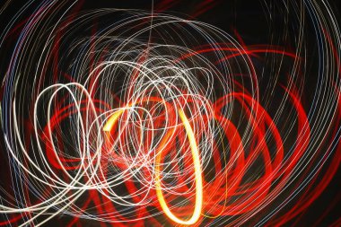 Koyu arka planda bulanık kırmızı ve beyaz çizgiler.