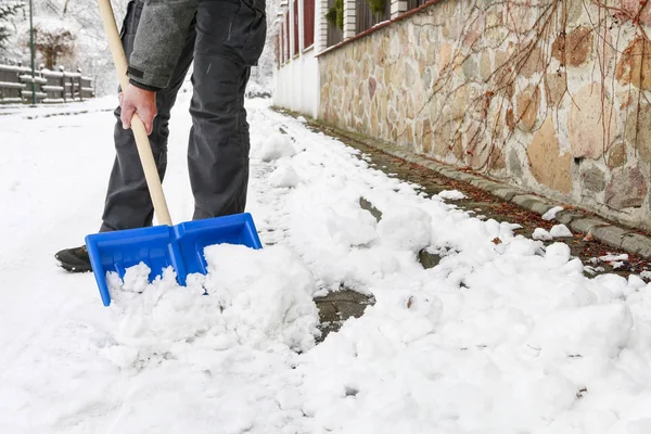 Man att ta bort snö från trottoaren efter snöstorm. — Stockfoto