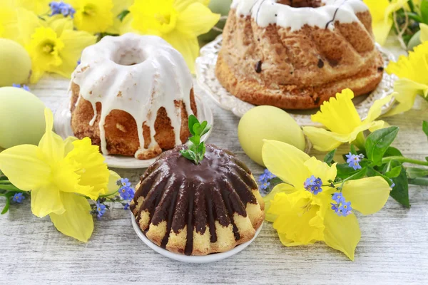 Traditional easter cakes and bouquet of daffodils in the backgro — Stock Photo, Image