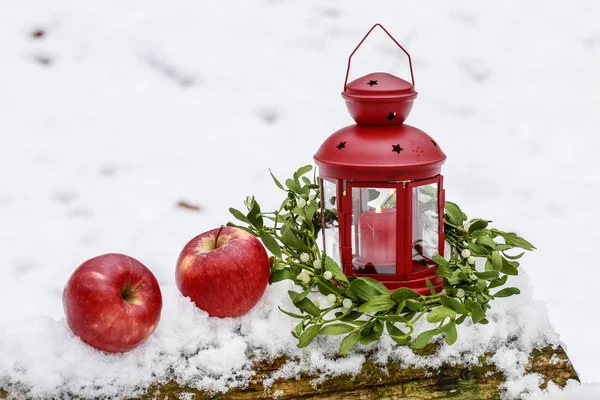 Rote Laterne, Mistelkranz und zwei Äpfel auf Schnee — Stockfoto