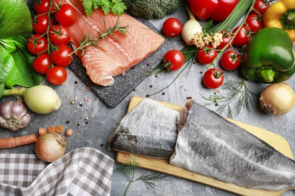 Raw fishes and vegetables on stone background — Stock Photo, Image