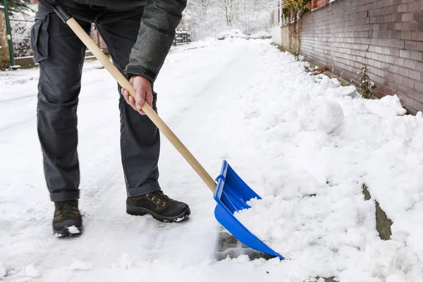 Hombre quitando nieve de la acera después de la tormenta de nieve . —  Fotos de Stock