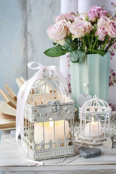 Vintage birdcage with cande and bouquet of pink roses in ceramic — Stock Photo, Image