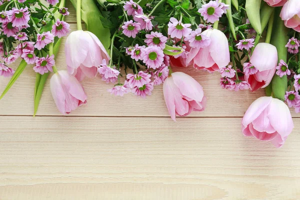 Pink tulips and chrysanthemums on wooden background — Stock Photo, Image