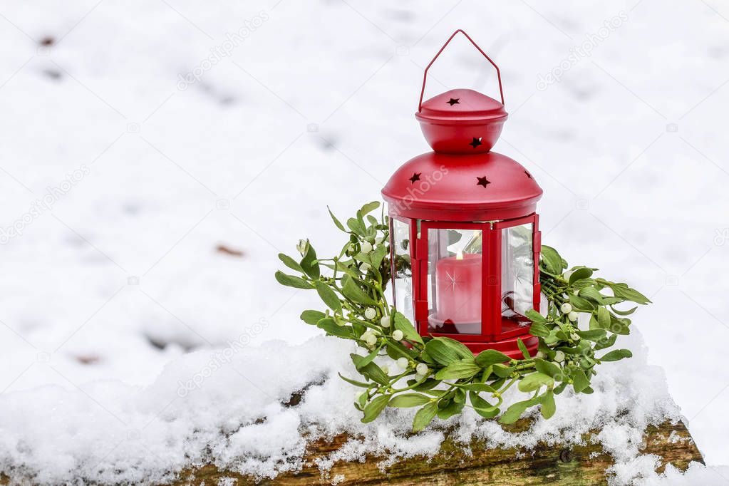 Red lantern and mistletoe wreath in winter garden