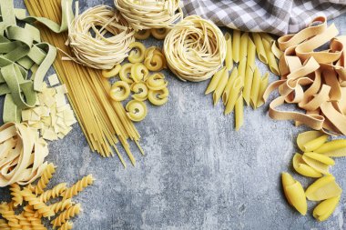 Karışık Türler ve gri taş üzerinde İtalyan makarna şekilleri, artalan