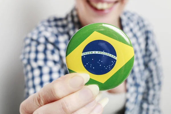 Vlag van Brazilië gedrukt op knop badge, holding door vrouw — Stockfoto