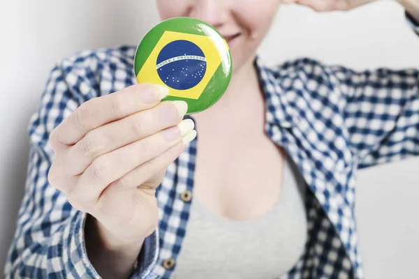 Düğme rozetine basılmış Brezilya bayrağı, kadın tarafından tutulan — Stok fotoğraf