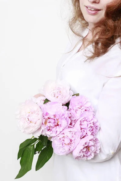 Mujer sosteniendo peonías rosadas . — Foto de Stock