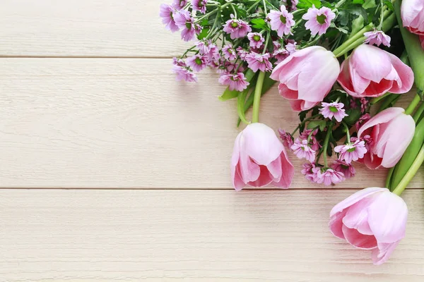 Tulipes roses et fleurs de chrysanthème sur fond de bois — Photo