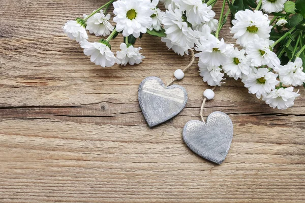 Corazones de madera entre flores de crisantemo blanco . —  Fotos de Stock