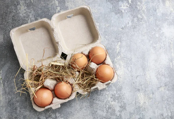 Eggs on hay in paper container — Stock Photo, Image
