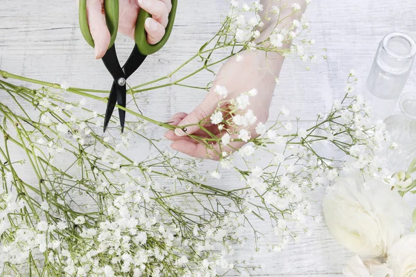 Mulher fazendo decorações com flores de ranúnculo e gesso branco — Fotografia de Stock