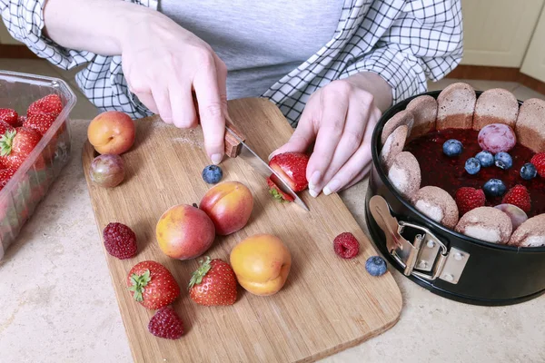 Mujer preparando pastel francés charlotte con frutas de verano en casa — Foto de Stock