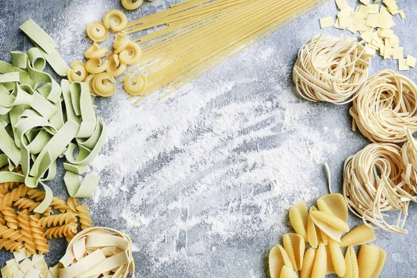 Tipos y formas mixtas de pasta italiana sobre fondo de piedra gris —  Fotos de Stock