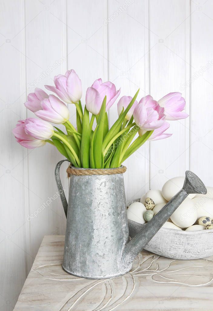 Bouquet of pink tulips in silver watering can.