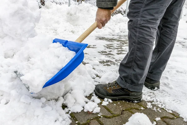 Man sneeuw uit de stoep te verwijderen na sneeuwstorm. — Stockfoto