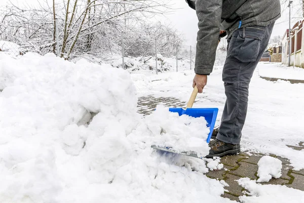 Hombre quitando nieve de la acera después de la tormenta de nieve . —  Fotos de Stock