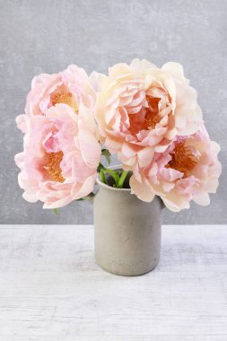 Gri taş arka planda pembe şakayık buketi