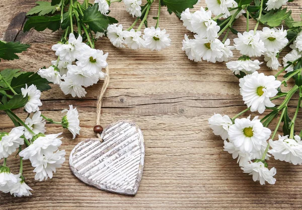 Corazón de madera entre flores de crisantemo blanco —  Fotos de Stock