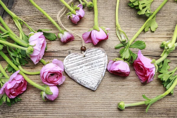 Corazón de madera y flores de buttercup persas rosadas —  Fotos de Stock