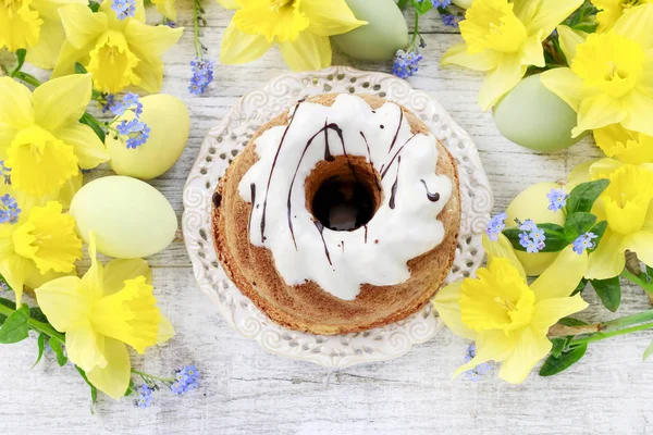 Traditional easter cake and bouquet of daffodils in the backgrou — Stock Photo, Image