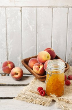 Şeftali reçeli ve şeftali rustik ahşap masa üzerinde kase.