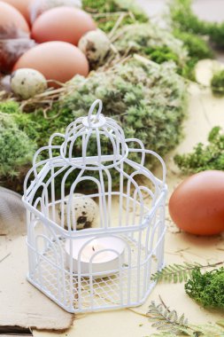 Etrafında mum, yosun ve Paskalya yumurtaları ile Vintage kuş kafesi.