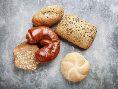 Gri taş arka plan üzerinde çeşitli çörekler.