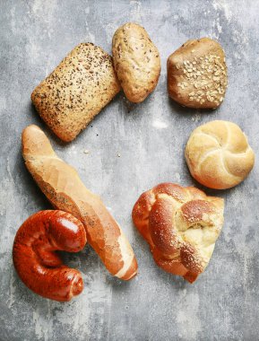 Gri taş arka plan üzerinde çeşitli çörekler.